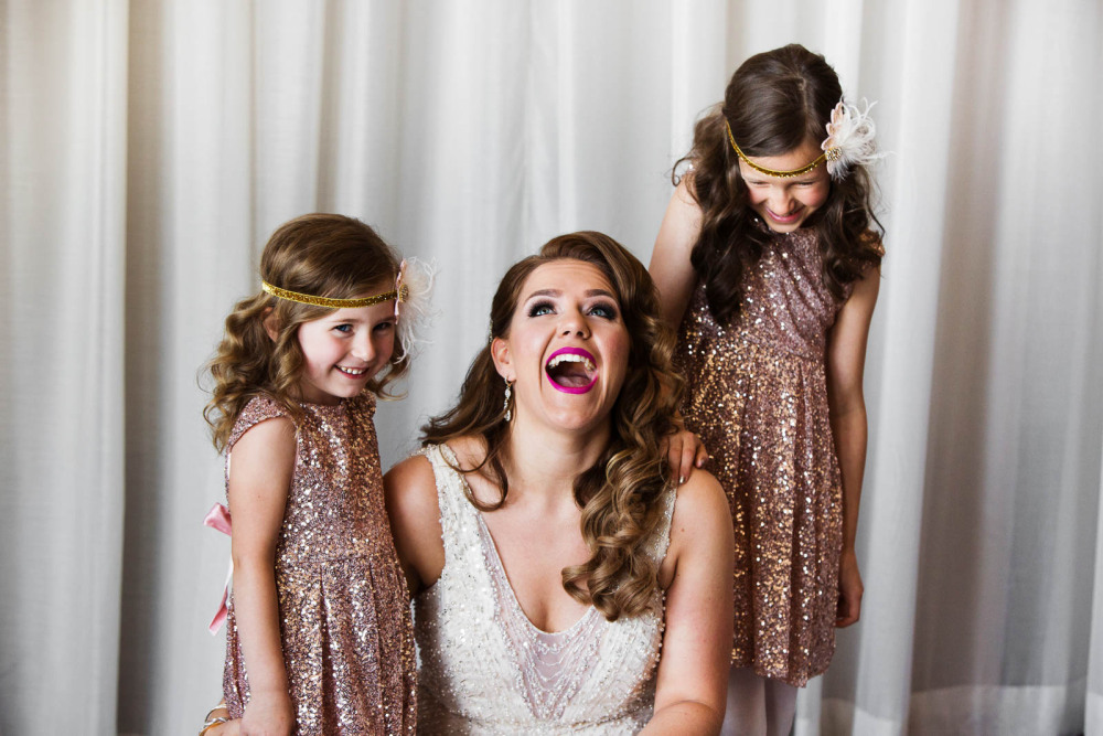 A bride laughing with her flower girls